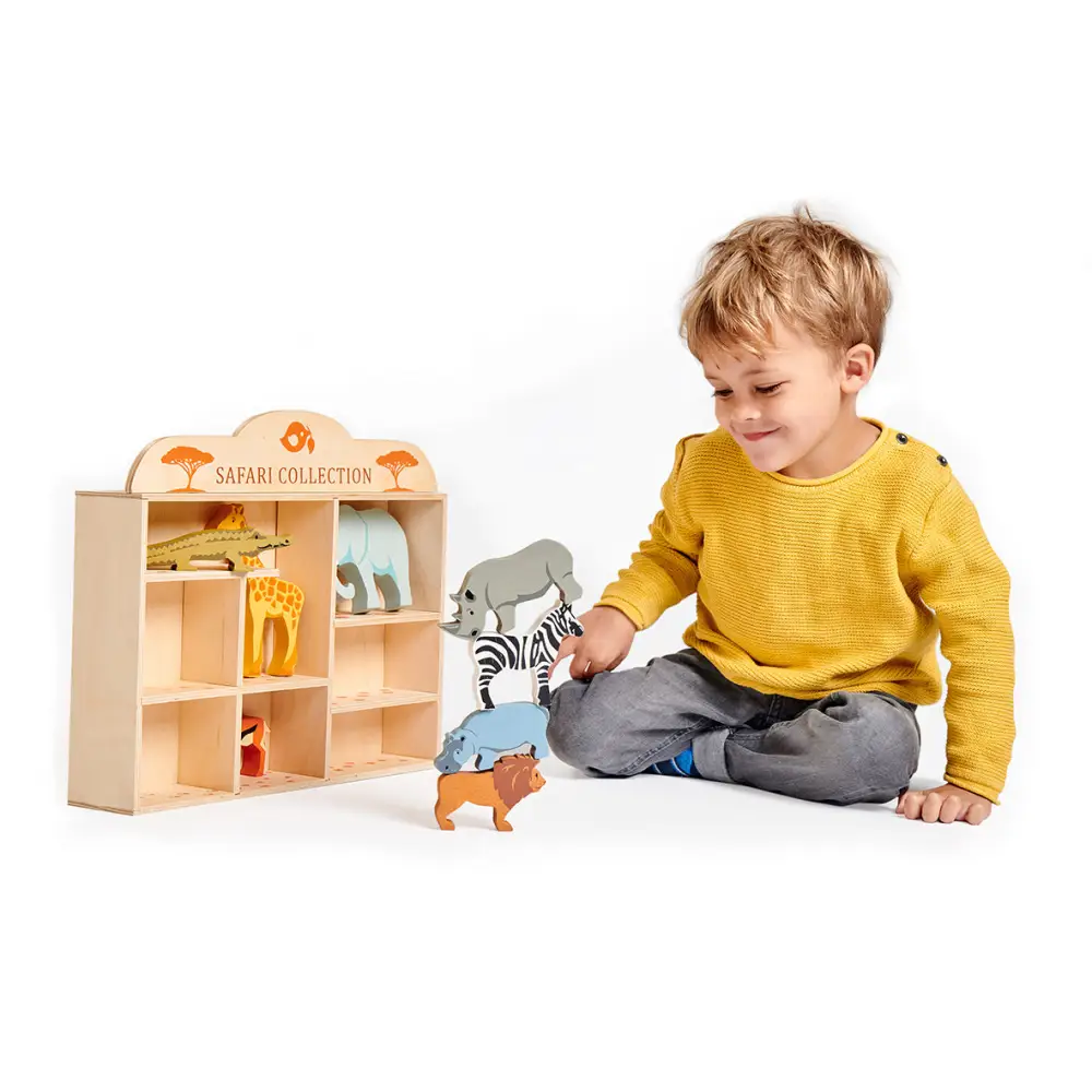A boy stacking the animals from Tenderleaf Toys Safari shelf