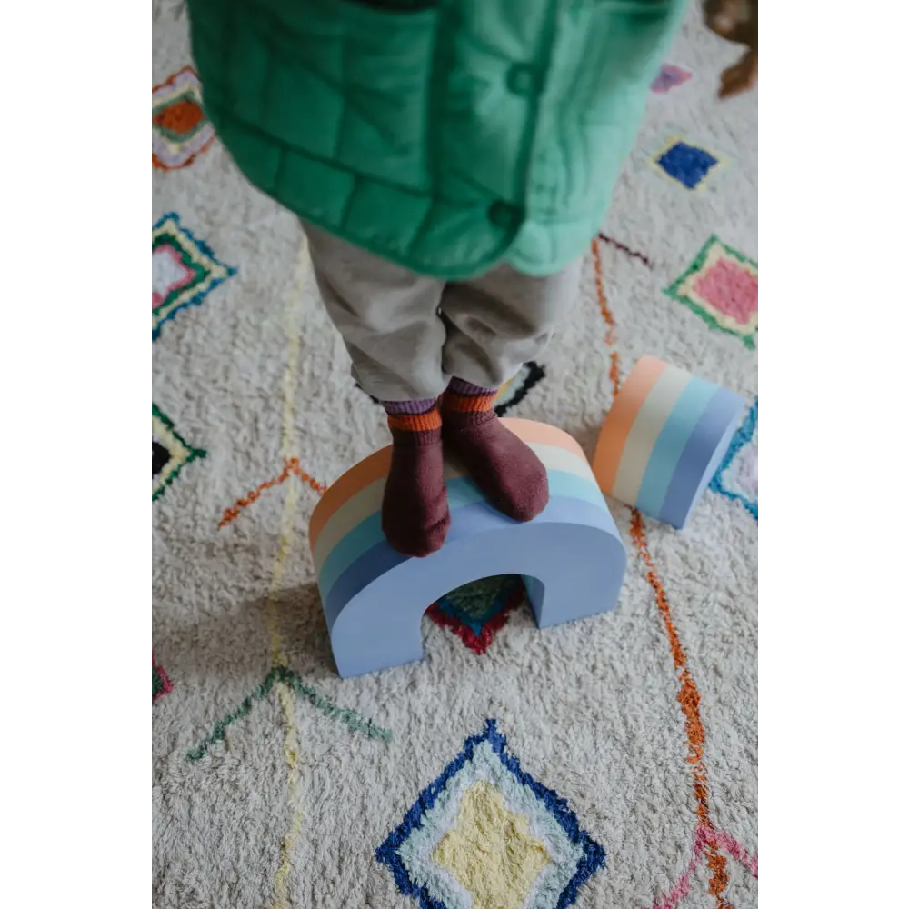 A child standing on the Moes foam rainbow