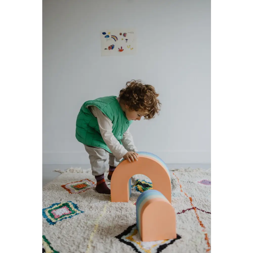A child playing with the Moes foam rainbow and mini