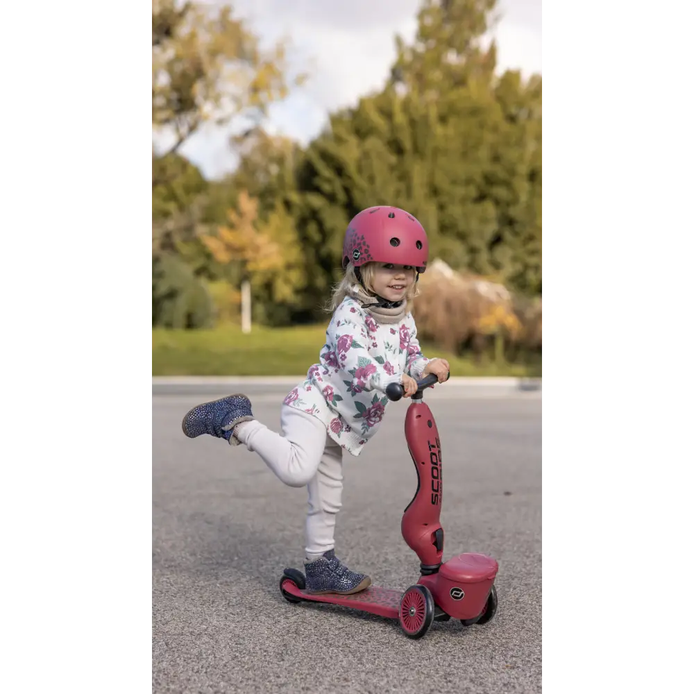 A girl with the Scoot & Ride Wildcat helmet and scooter