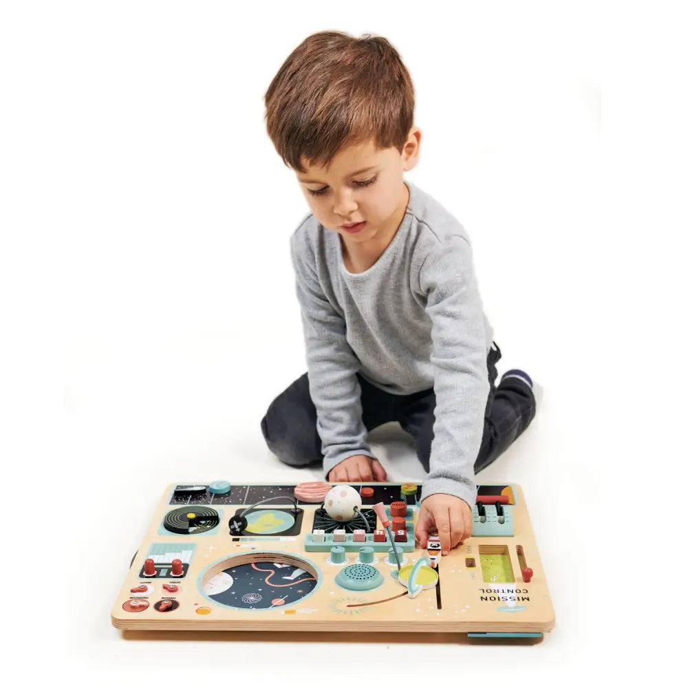 Boy playing with Tenderleaf Toys Space Station Busy Board